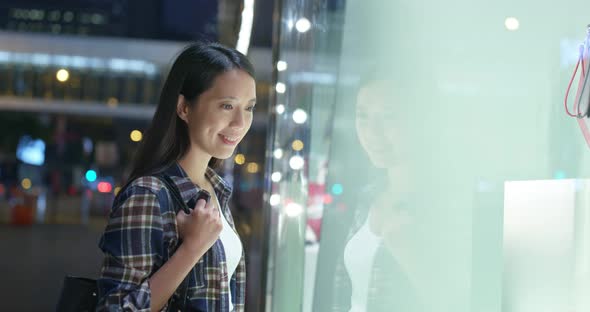 Woman shop in the city, look though the glass of window at outdoor