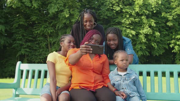 Happy Black Mom and Lovely Daughter Posing for Selfie Shot Outdoors