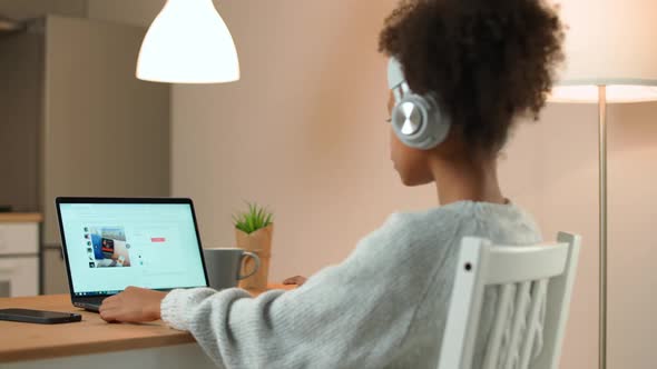 Shopping Online African Female Sits at a Desk and Uses a Laptop Surfing the Internet a Woman Visits