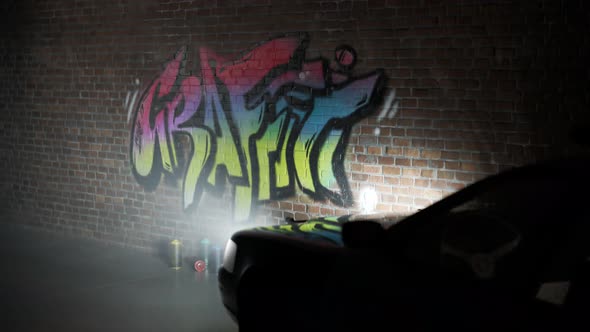 Police car lights illuminating old brick wall with fresh graffiti tag on it.4KHD