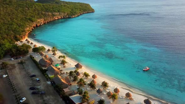 Aerial dolly out view of Cas Abao Beach with a boat on the shore on the Dutch island of Curacao at s