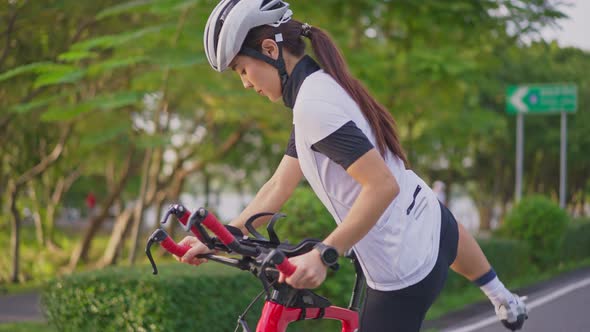 Asian young beautiful sport woman athlete riding bicycle for health in the evening in public park.