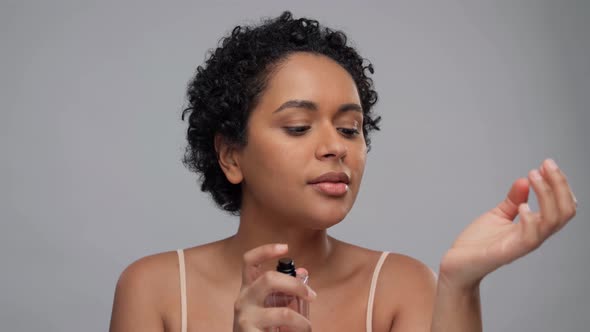 Young African American Woman Using Perfume