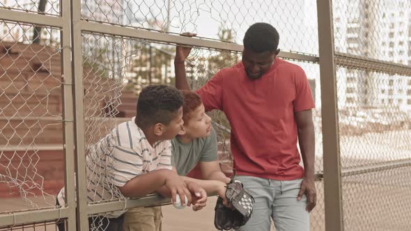 Father Talking to Sons during Baseball Training