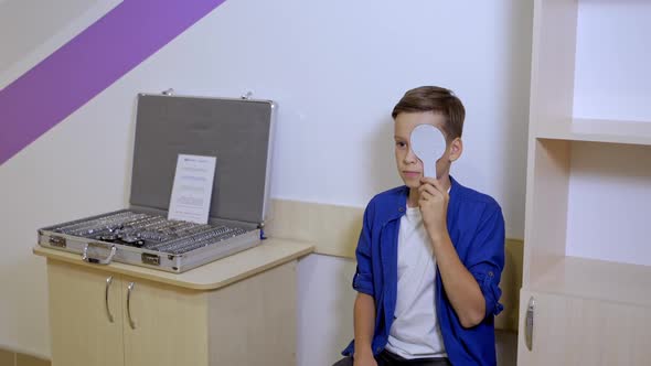 Professional ophthalmologist checks the eyesight of the child