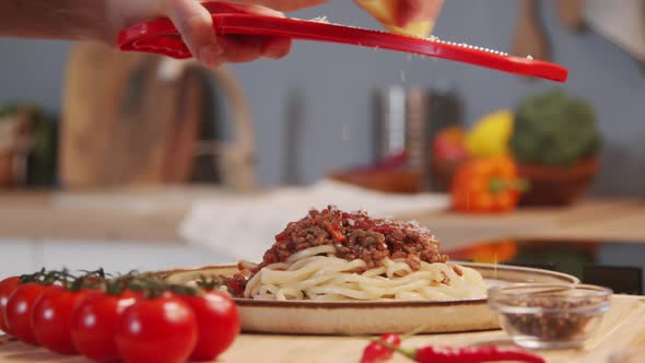 Grating Cheese over Top of Spaghetti Bolognese