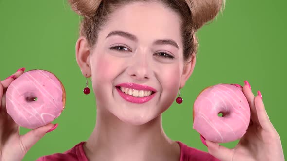 Teenager Sniffs Two Donuts. Green Screen