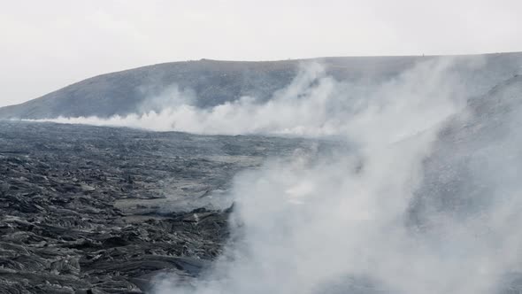 Smoke And Steam Rising From Volcanic Lava Filed In Landscape