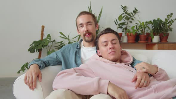 LGBT Couple is Sitting Together on the Sofa and Taking a Moment to Enjoy Each Other