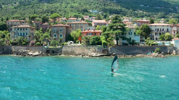 Aerial Footage of Drone Following a Person Practicing Wind Surfing or Sailboard Sport in the Sea