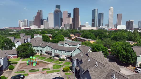 Residential homes with children playground with urban city skyline in distance. Houston Texas. Popul