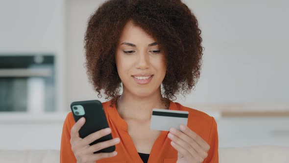 African American Woman Paying Online with Financial Mobile Service at Home Kitchen