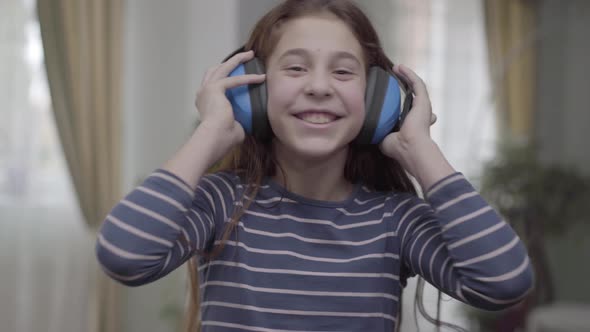 Happy Girl with Headphones Dancing and Listening To the Music