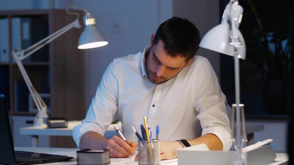 Businessman with Files and Laptop Working at Night 28