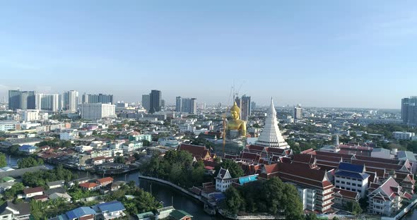 Big Golden Buddha sitting in a city landscape, Wat Paknam under construction. DRONE AERIAL