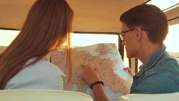 Friends Using Map Traveling In Car In Summer. Handsome Man And Beautiful Woman.