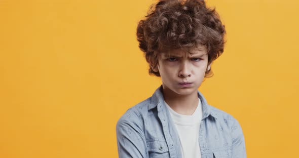 Naughty Boy Pouting Lips, Feeling Offended, Turning Away From Camera, Orange Studio Background