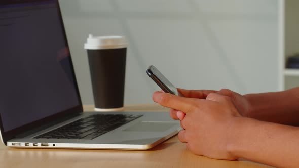 African American Man Using Smartphone and Laptop Closeup