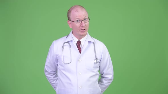 Mature Bald Man Doctor Talking To Camera Explaining Something