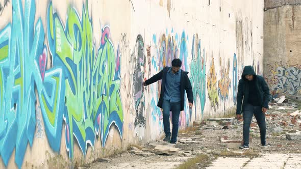 Drawing a graffiti painted wall with a stone.