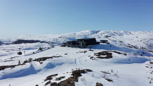 Amazing scenic shot of gondola cabins leaving and arriving Hangurstoppen mountain station at Voss -