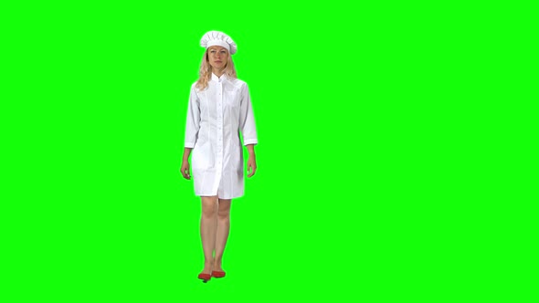 Blonde Cook Chef in White Uniform and Hat Going Against a Green Screen.