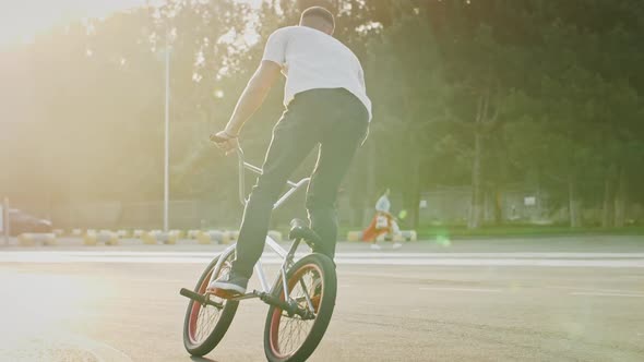 Young Male in Casual Outfit is Riding Bmx Bicycle Jumping and Spinning on Its Axis in the Air Doing