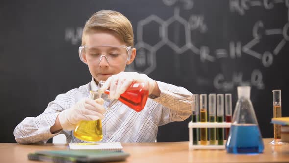 Boy in Protective Glasses Mixing Chemical Liquids in Flasks, Curious Genius