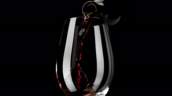 Camera follows red wine pouring into glass. Slow Motion.