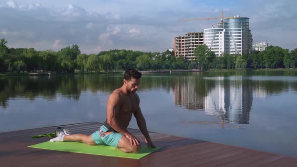 Young Handsome Sports Man Doing Body Activity on Lake Pier