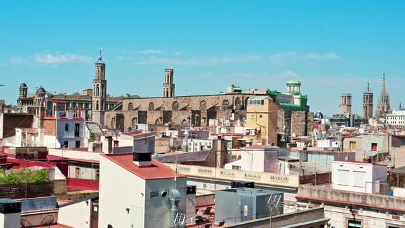 Panoramic view of Barcelona, multiple building's roofs, old cathedrals, Spain