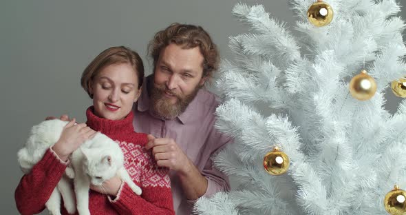 Portrait of Bearded Caucasian Man and Blonde Woman with Short Haircut in Red Sweater Holding White