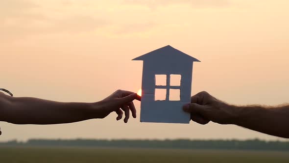 Hand of a Woman and a Man Close-up, A Man Gives a Model of the House To a Woman at Sunset.