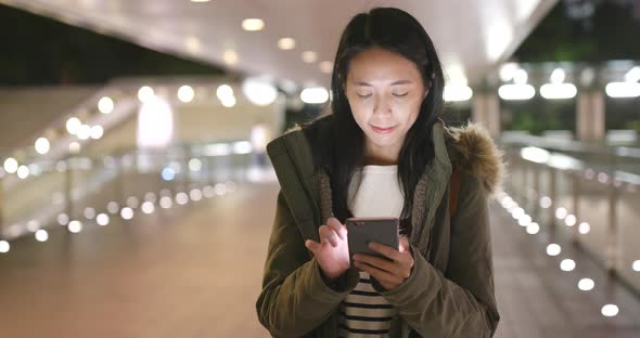 Woman use of smart phone in city at night