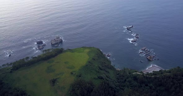 Aerial drone flight over Gueirua beach in Asturias province. Green cliffs meeting endless ocean