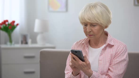 Upset Senior Female Typing Message on Smartphone, Missing Family, Loneliness