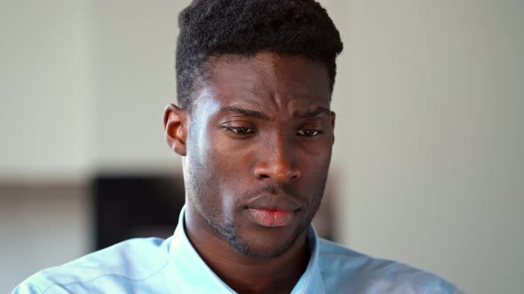 Portrait of a serious young african american man looking at screen laptop