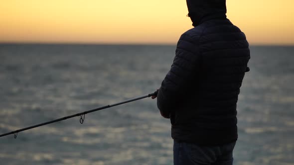 Man Hobby Fishing on Sea Tightens a Fishing Line Reel of Fish Summer