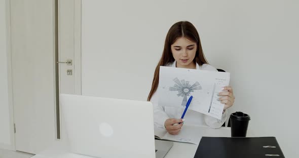 Girl Explaining the Topic with Image at Laptop at Workplace in Office