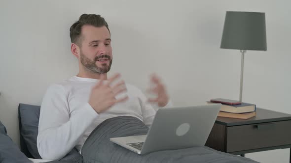 Man Doing Video Call on Laptop in Bed