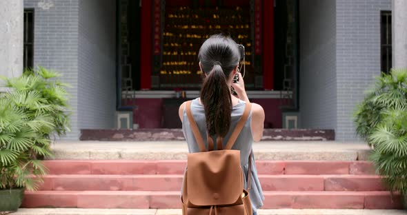 Woman taking video on camera in Chinese temple