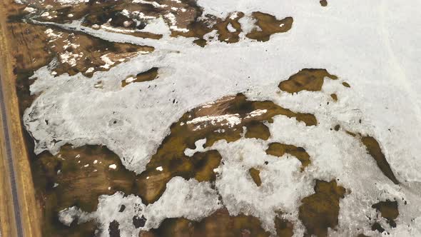 Aerial View Of Road Through Ponds In Winter Snowy Landscape