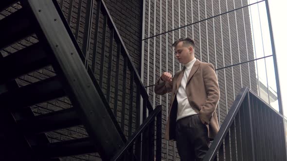 Stylish Male Businessman in Brown Coat Near Office Center Waiting for Business Meeting