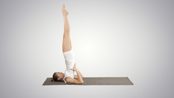 Woman practicing yoga standing in salamba sarvangasana