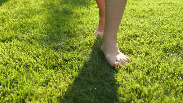 Closeup of Barefoot Woman Walking on Grass Lawn at Park