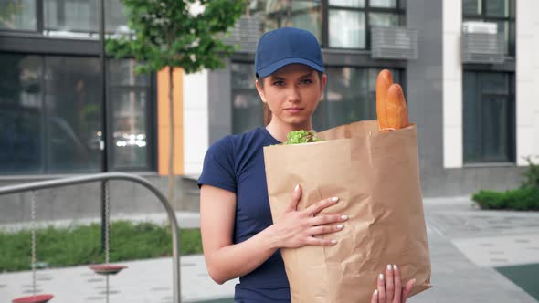 Portrait Food Delivery Woman Courier Holds Paper Bag with Groceries in Hands