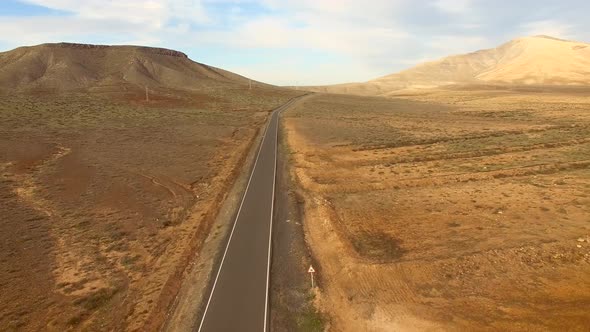 Aerial view of an empty road in dryland of Fuerteventura.