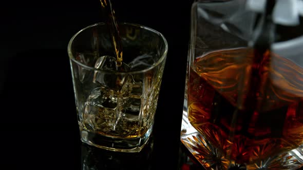 Super Slow Motion Shot of Pouring Whiskey Into Glass with Ice Cubes at 1000Fps with Camera Movement.