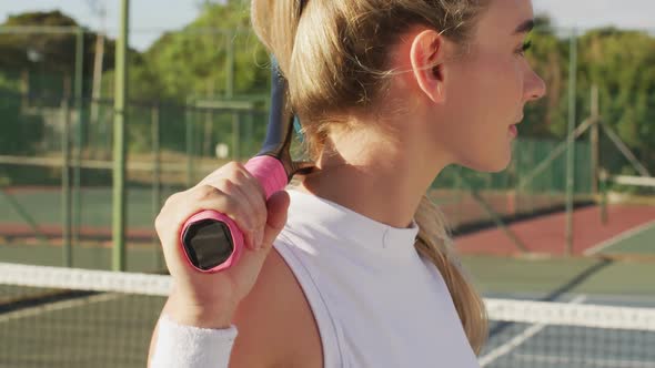 Video of caucasian female tennis player holding racket and looking at camera