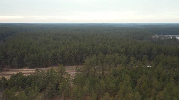 AERIAL: Train Stops at Remote and Isolated Train Station in the Middle of Forest